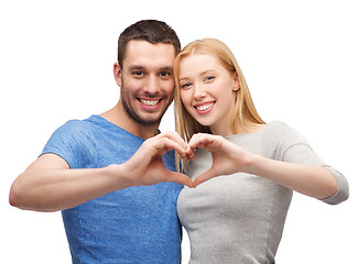 Image showing smiling couple showing heart with hands