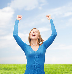 Image showing laughing young woman with hands up