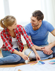 Image showing smiling couple looking at color samples at home