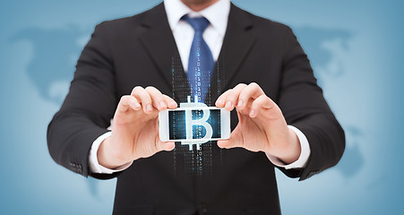 Image showing businessman with smartphone and bitcoin on screen