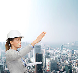 Image showing smiling architect in white helmet with blueprints