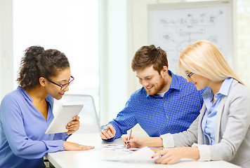 Image showing smiling team with table pc and papers working