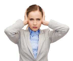 Image showing stressed businesswoman with covered ears