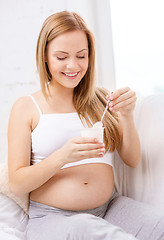 Image showing happy pregnant woman with yogurt