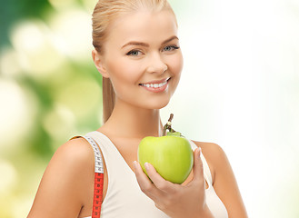 Image showing sporty woman with apple and measuring tape