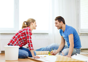 Image showing smiling couple measuring wallpaper