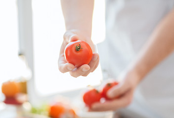 Image showing close up of male hands holding tomatoes