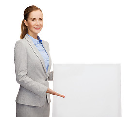 Image showing smiling businesswoman with white blank board