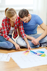 Image showing smiling couple looking at color samples at home