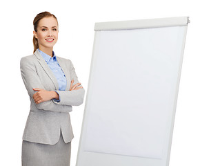 Image showing smiling businesswoman standing next to flipboard