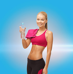 Image showing smiling woman with bottle of water and towel