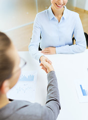 Image showing two smiling businesswoman shaking hands in office