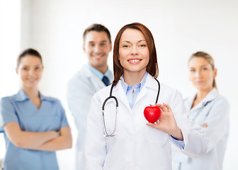 Image showing smiling female doctor with heart and stethoscope