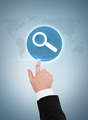 Image showing businessman hand pointing to magnifying glass