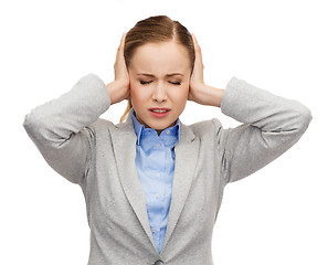 Image showing stressed businesswoman with covered ears