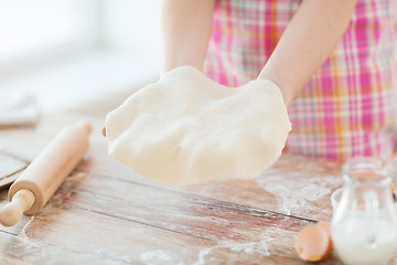 Image showing close up of female hands holding bread dough