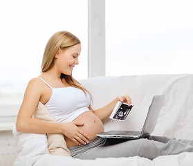 Image showing smiling pregnant woman with laptop computer