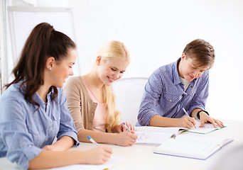 Image showing smiling students with notebooks at school