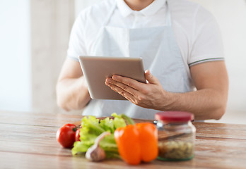 Image showing closeup of man reading recipe from tablet pc