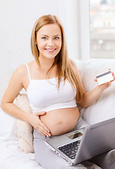 Image showing smiling pregnant woman with laptop computer