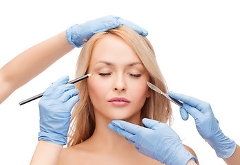 Image showing woman and beautician hands with pencil and scalpel