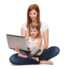 Image showing happy mother with adorable little girl and laptop