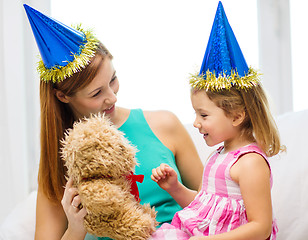 Image showing mother and daughter in blue hats with teddy bear