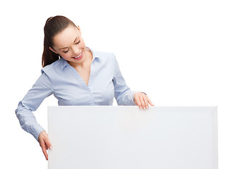 Image showing smiling businesswoman lookint at white blank board