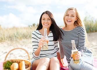 Image showing girlfriends with bottles of beer on the beach