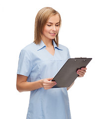 Image showing smiling female doctor or nurse with clipboard