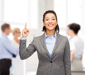 Image showing smiling businesswoman with her finger up at office