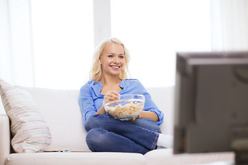Image showing young girl with popcorn watching movie at home