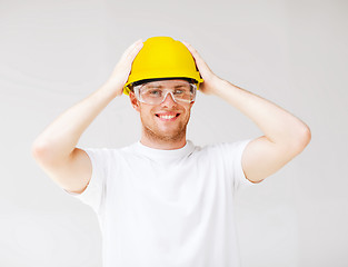 Image showing male builder in safety glasses and yellow helmet