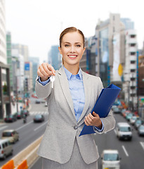 Image showing smiling businesswoman with folder and keys