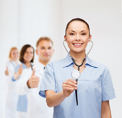 Image showing smiling female doctor or nurse with stethoscope