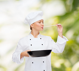 Image showing smiling female chef with pan and spoon