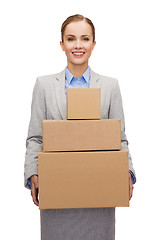 Image showing smiling businesswoman holding cardboard boxes