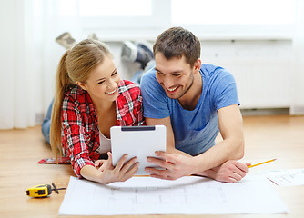 Image showing smiling couple looking at tablet pc at home