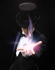 Image showing magician holding something on palm of his hand