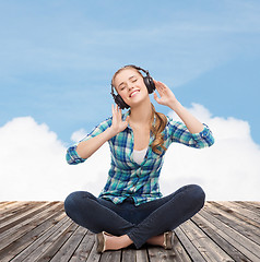 Image showing young woman listeting to music with headphones