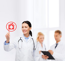 Image showing smiling female doctor pointing to something