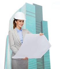 Image showing smiling architect in white helmet with blueprints