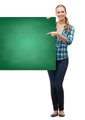 Image showing smiling young woman with green blank board