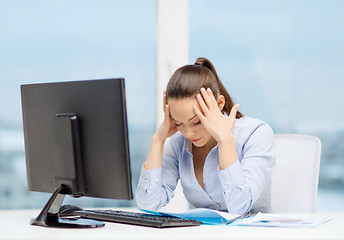 Image showing stressed woman with computer and documents