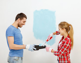 Image showing smiling couple painting wall at home