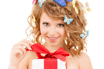 Image showing teenager with butterflies in hair opening present