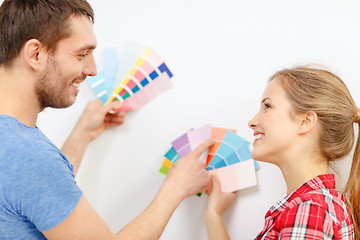 Image showing smiling couple looking at color samples at home