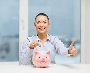 Image showing smiling woman with piggy bank and cash money