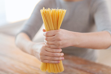 Image showing close up of female hands holding spaghetti pasta