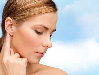 Image showing calm woman touching her ear